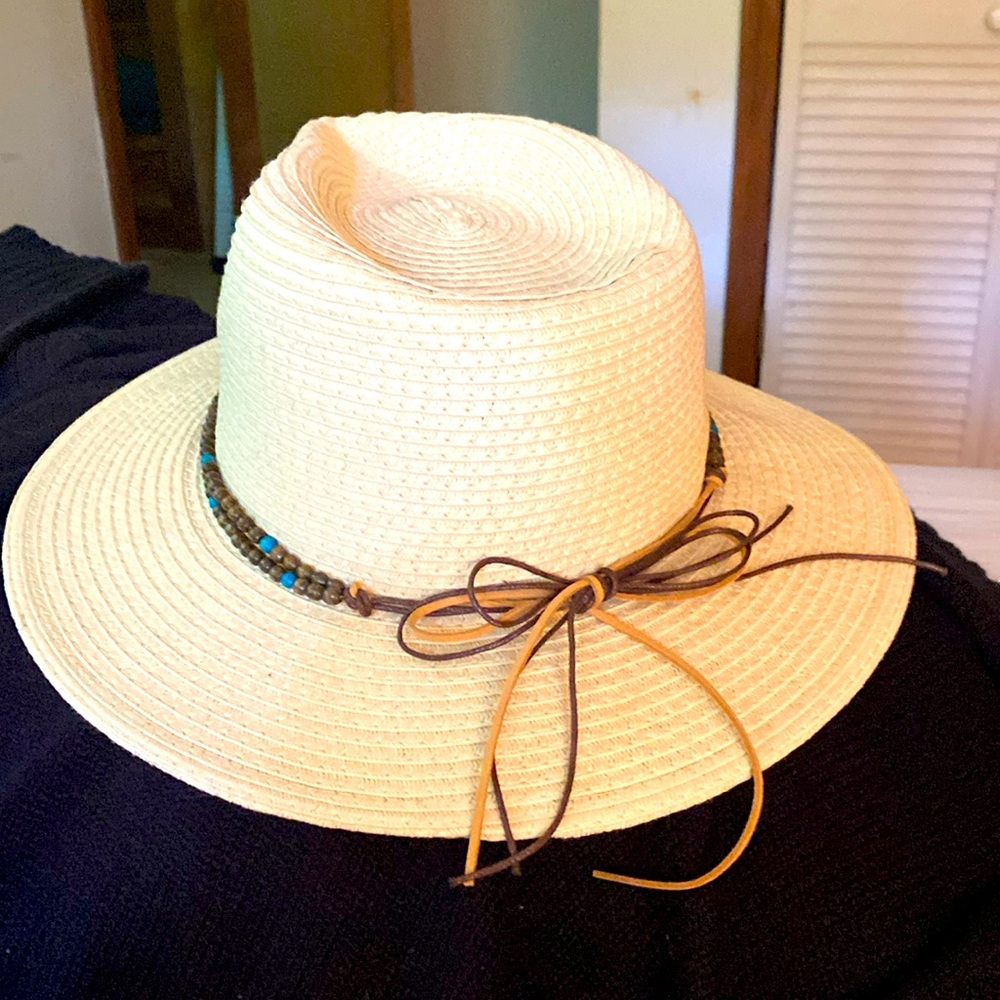 Women’s straw hat with leather details and wooden beading.